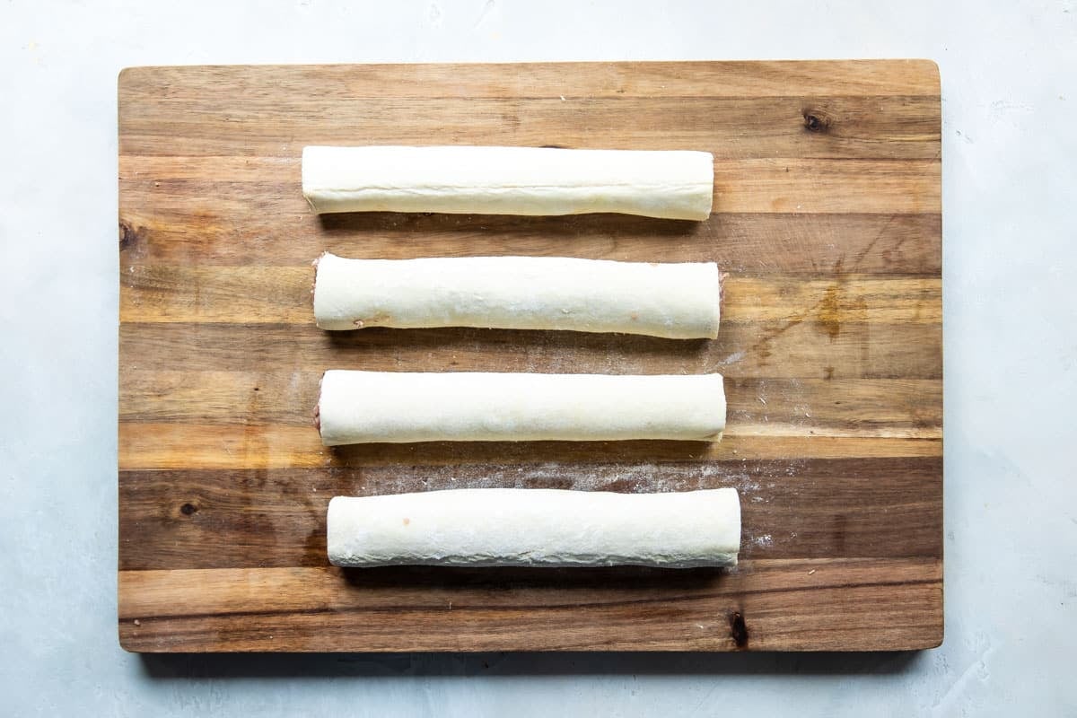 Four logs or rolls of sausage rolls before being sliced.