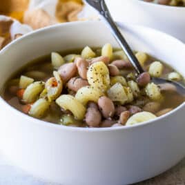Slow cooker pasta and bean soup in a white bowl.