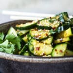 Asian cucumber salad in a black bowl.