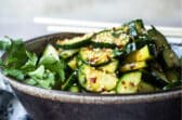 Asian cucumber salad in a black bowl.