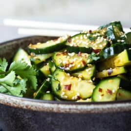 Asian cucumber salad in a black bowl.