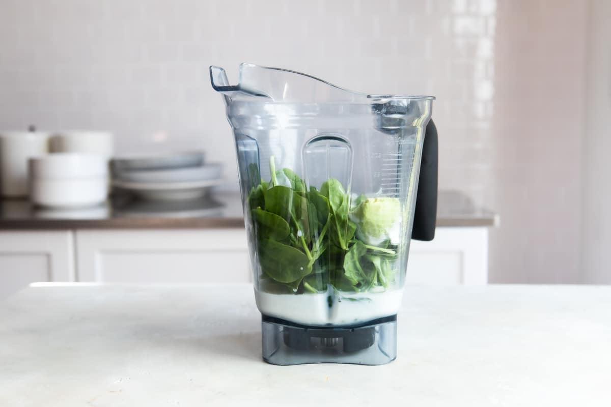 Ingredients in a blender for an avocado smoothie.
