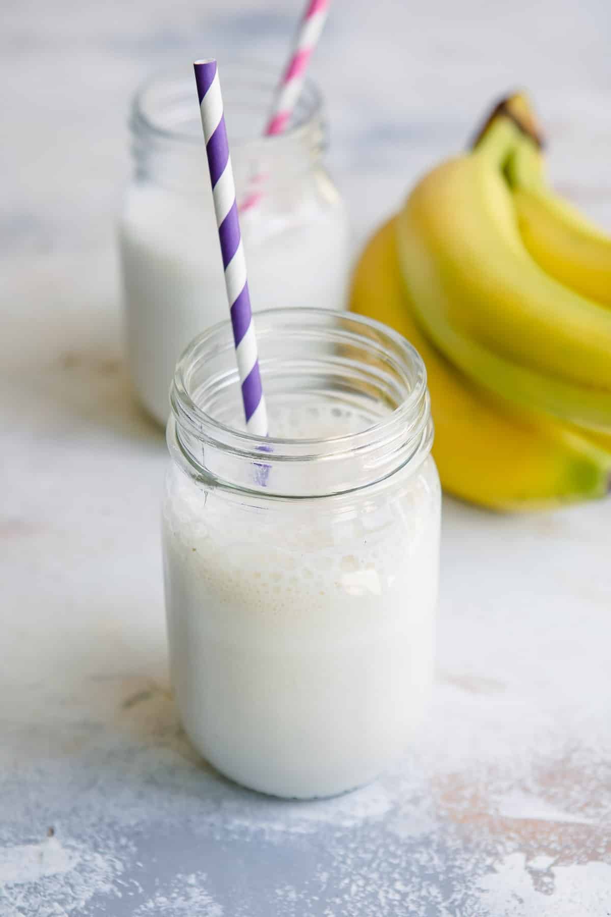2 jars with Banana Smoothies and straws.
