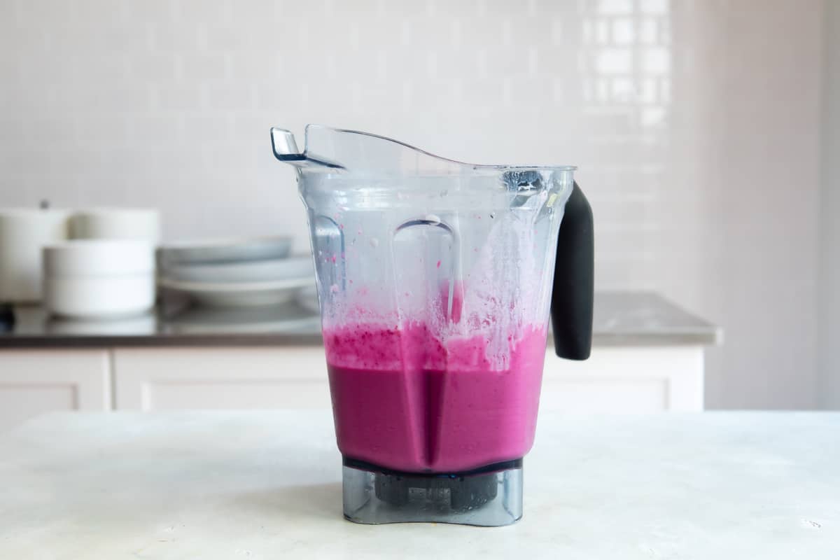 A blender filled with beet smoothie ingredients.