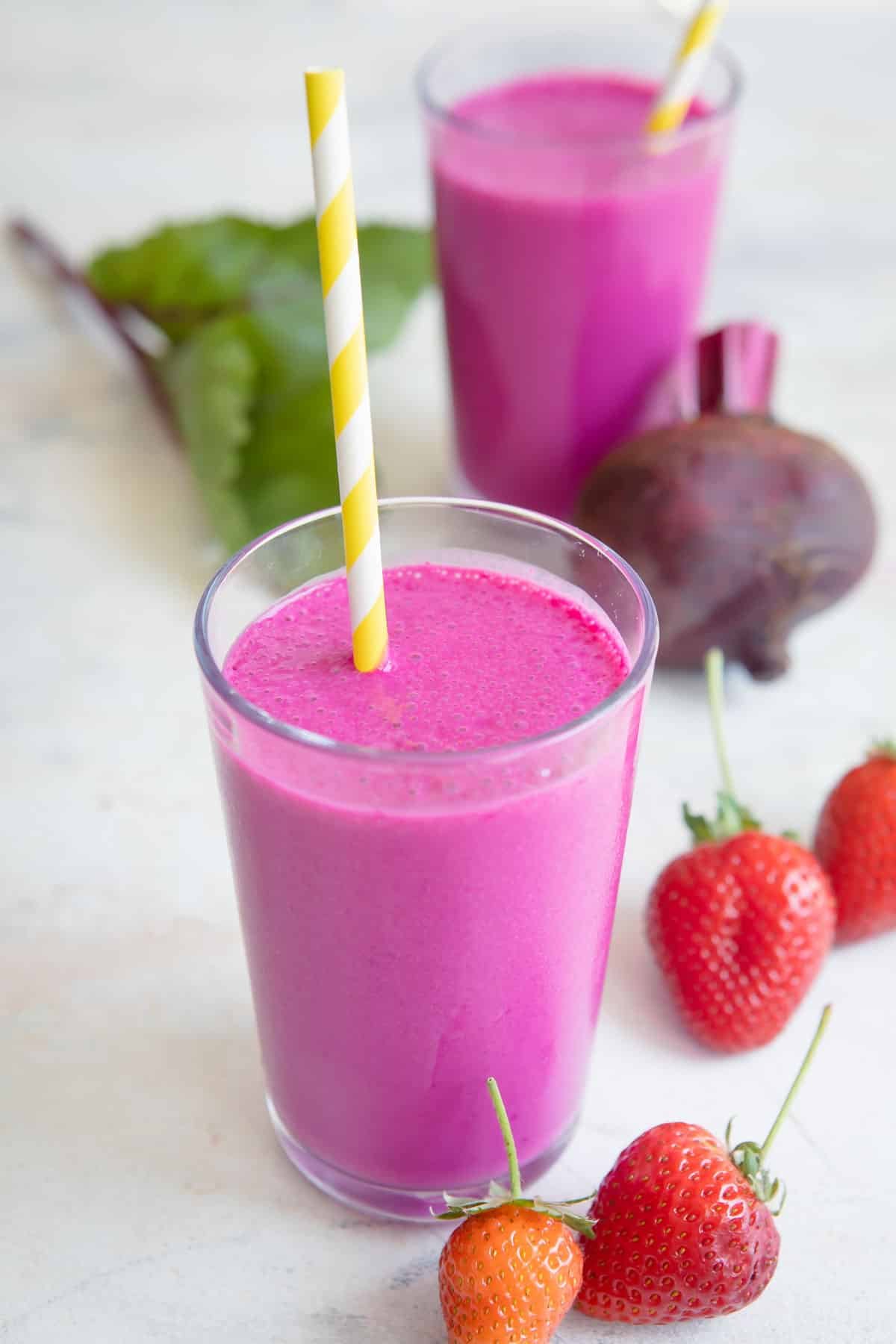 2 glasses of beet smoothie with straws.