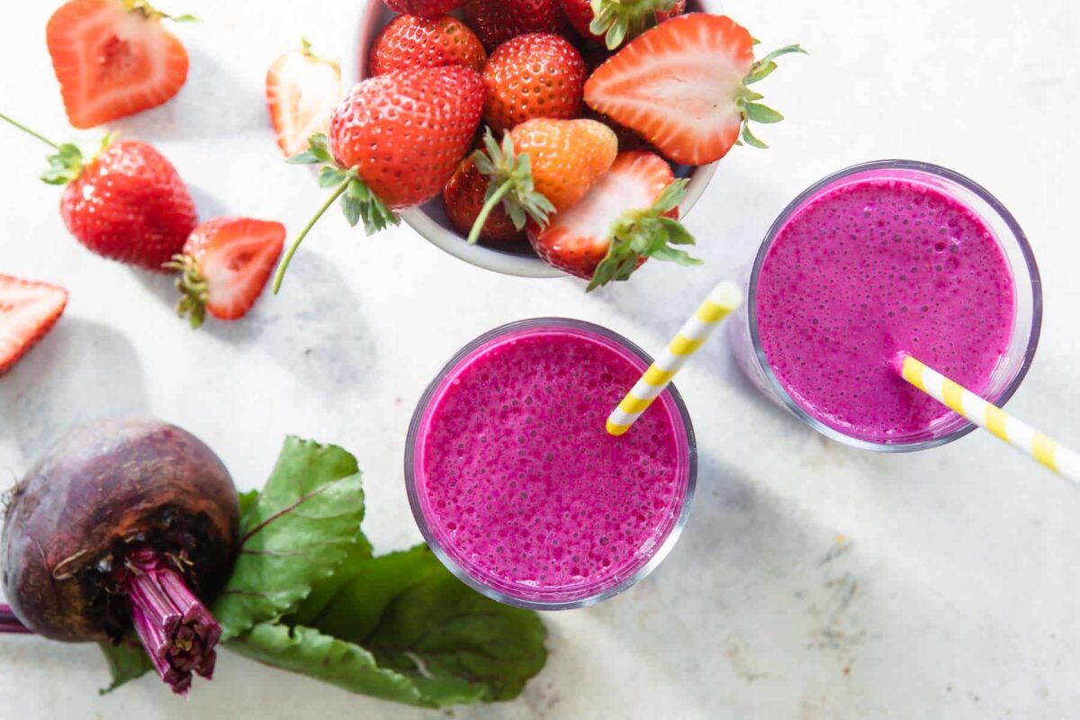 2 glasses of beet smoothie with straws.