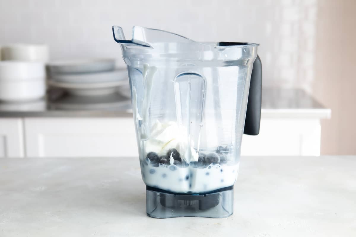 Blueberry smoothie ingredients in a blender.