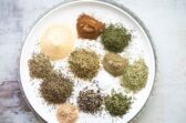 A plate with greek seasoning spices on it.