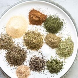 A plate with greek seasoning spices on it.