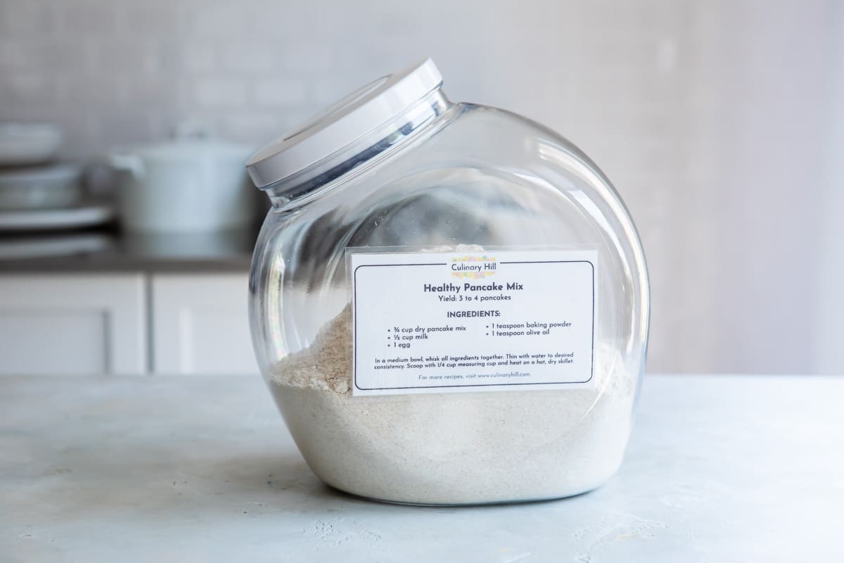 A plastic container full of dry pancake mix.