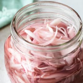 A clear jar of pickled shallots.