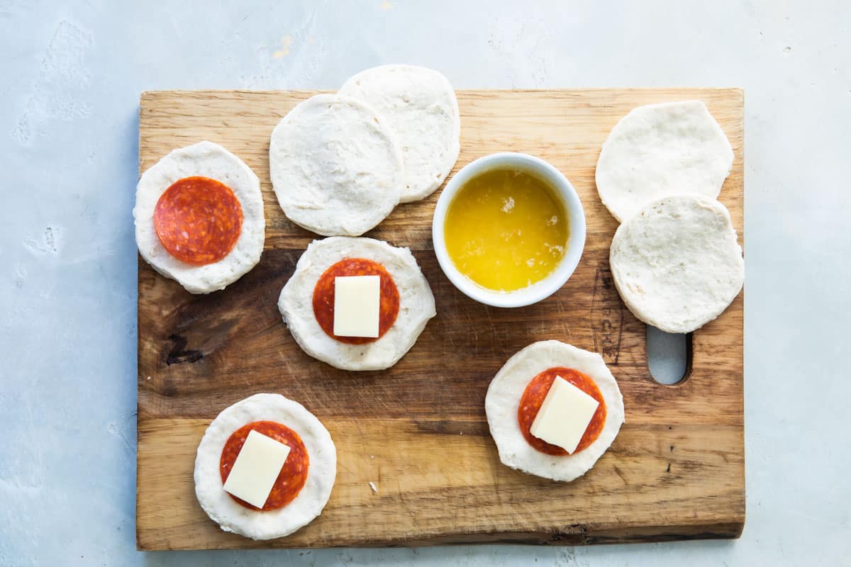 Someone assembling pull-apart pizza bread.