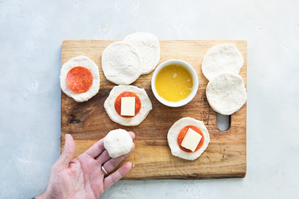 Someone assembling pull-apart pizza bread.
