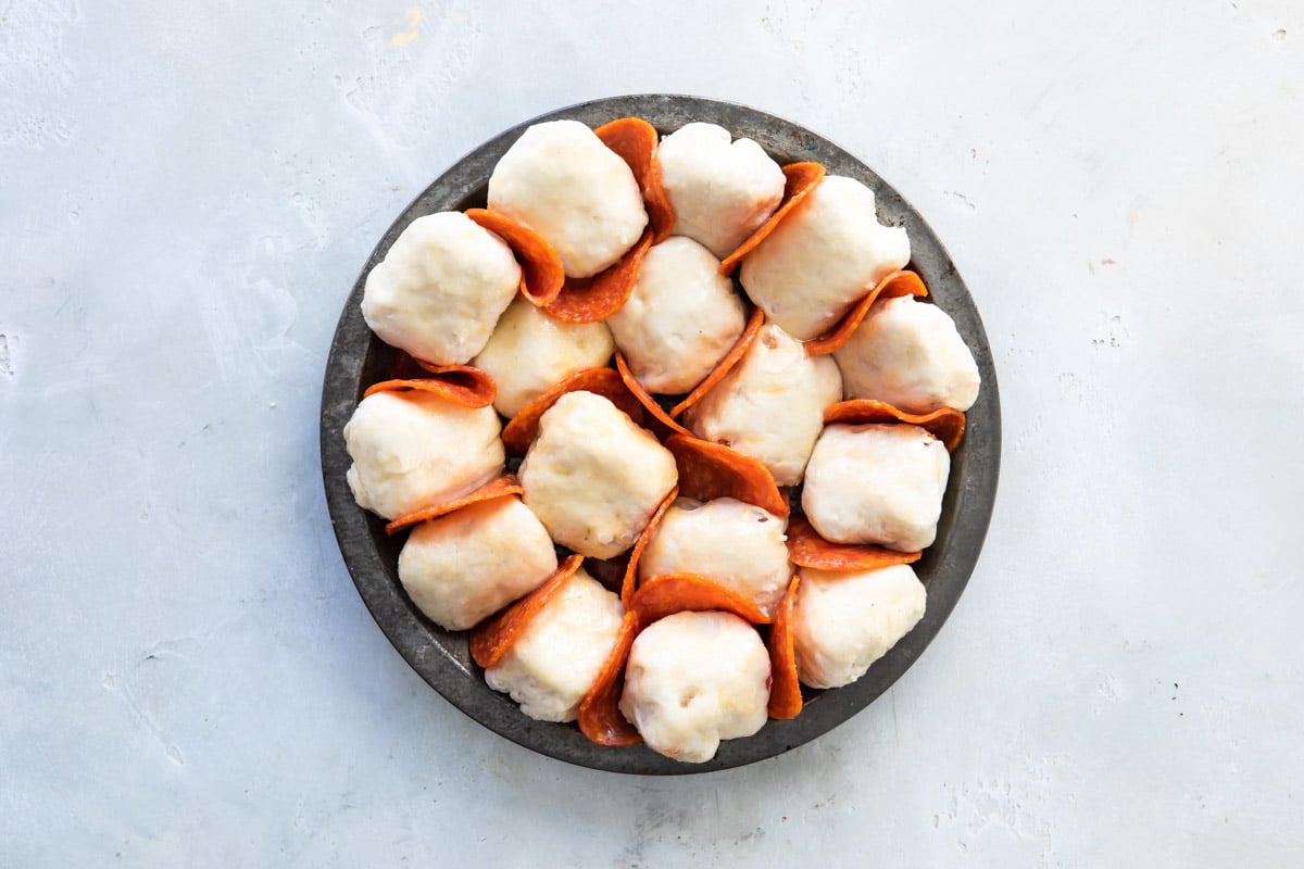 pull-apart pizza bread in a pan before baking (with pepperoni).