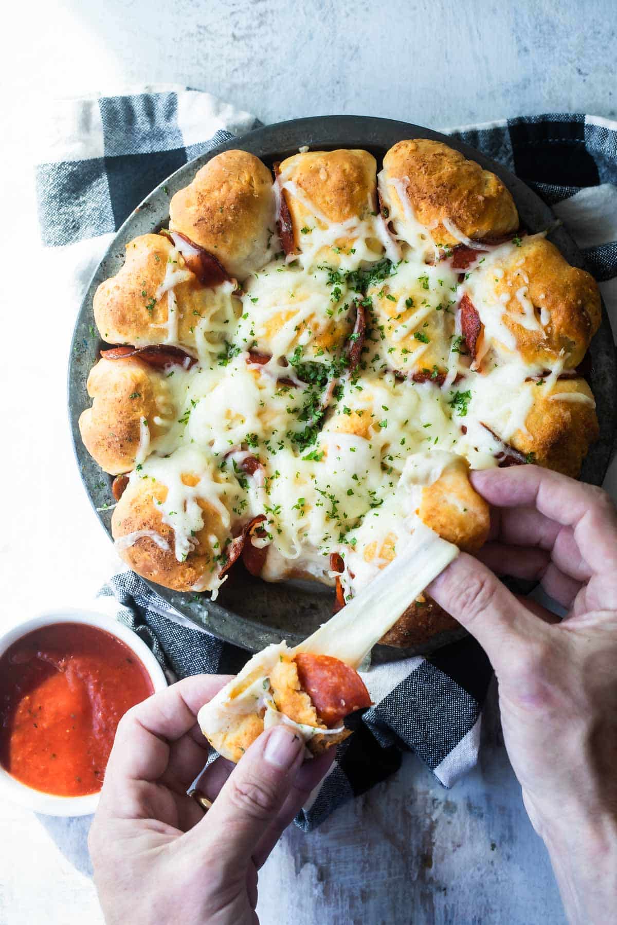 A pan of pull-apart pizza bread served with marinara.