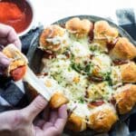 A pan of pull-apart pizza bread served with marinara.