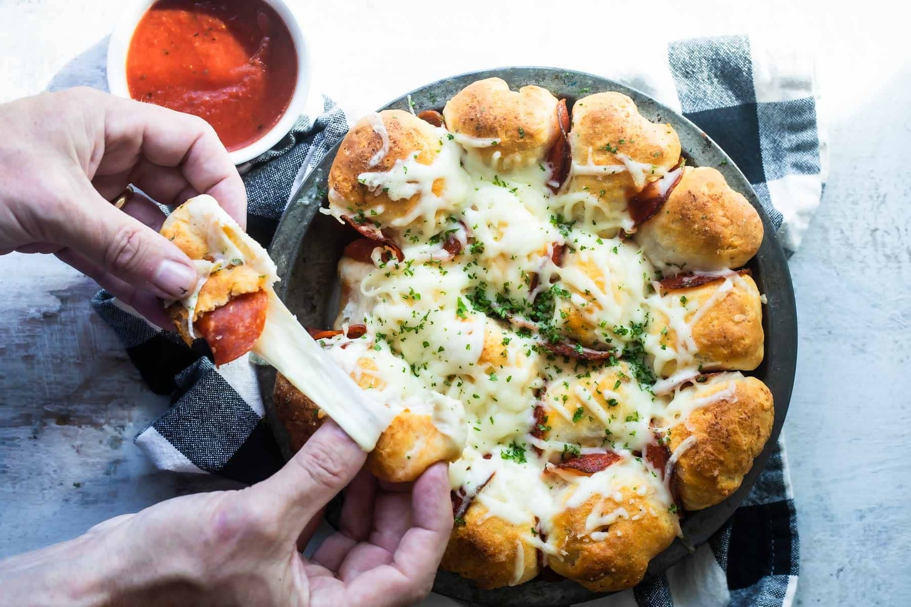 A pan of pull-apart pizza bread served with marinara.