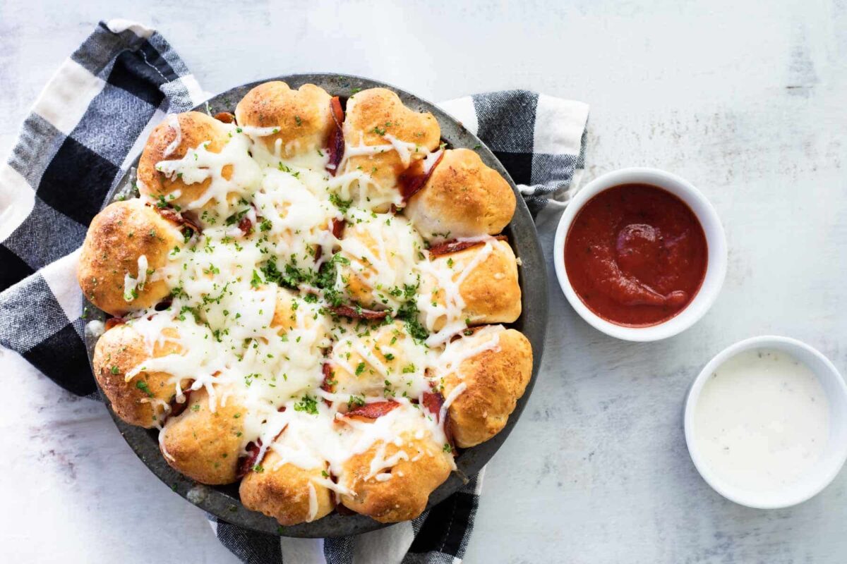 A pan of pull-apart pizza bread served with marinara.