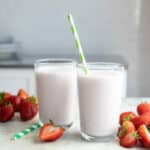 2 glasses full of strawberry smoothie.