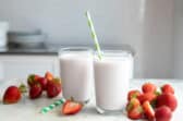 2 glasses full of strawberry smoothie.