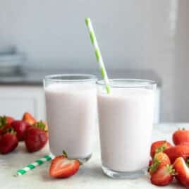 2 glasses full of strawberry smoothie.