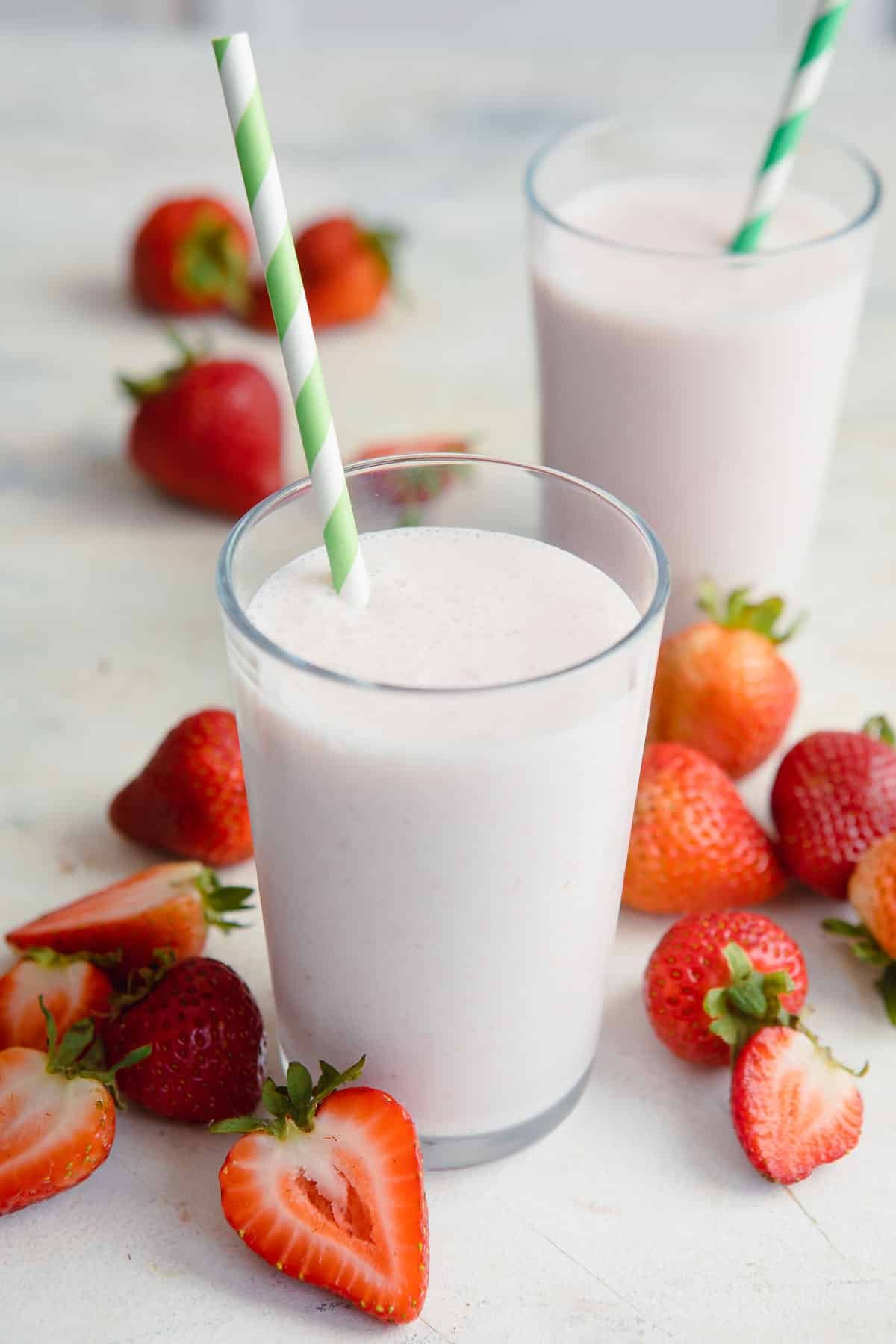 2 glasses full of strawberry smoothie.