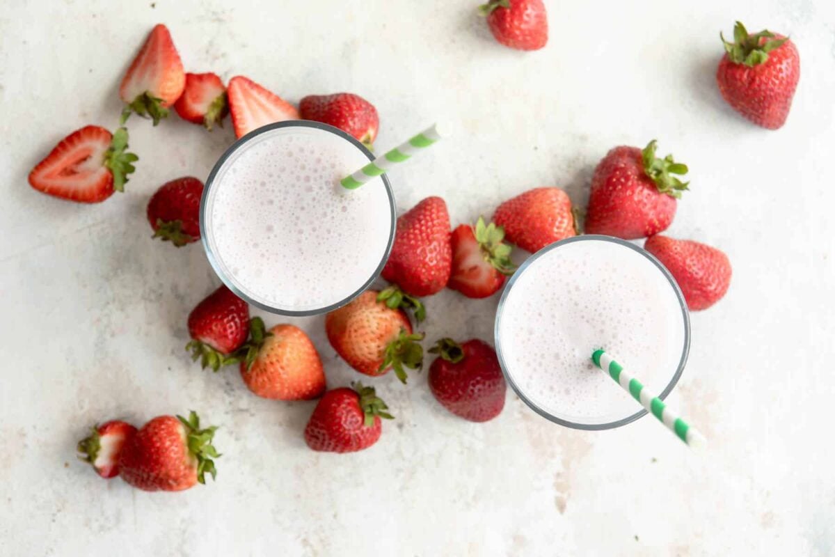 2 glasses full of strawberry smoothie.