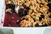 A fully-baked Blackberry Crisp in a white baking dish.