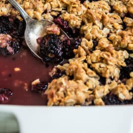A fully-baked Blackberry Crisp in a white baking dish.