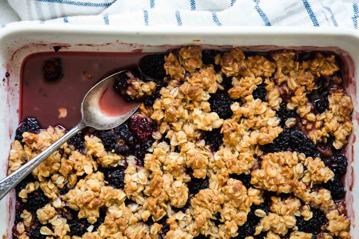 A fully-baked Blackberry Crisp in a white baking dish.