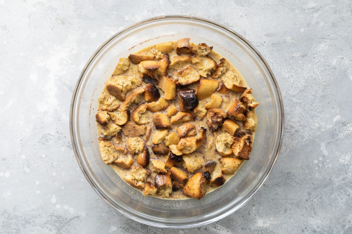 Chunks of bread soaking in a bread pudding sauce.