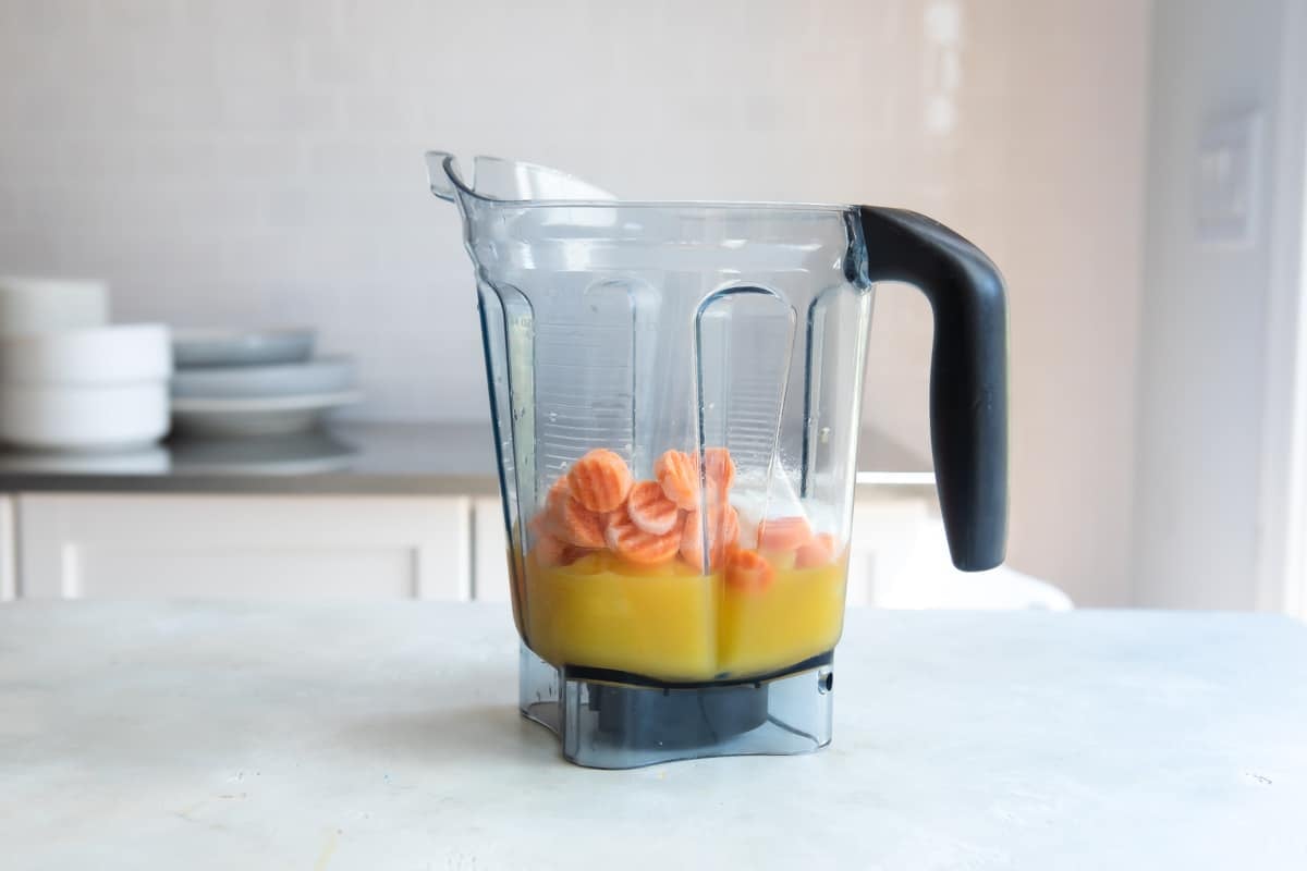 Carrot smoothie ingredients in a blender.