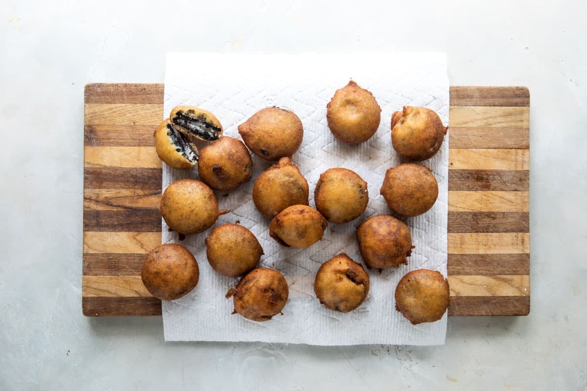 A board with paper towels and deep-fried oreos on top.