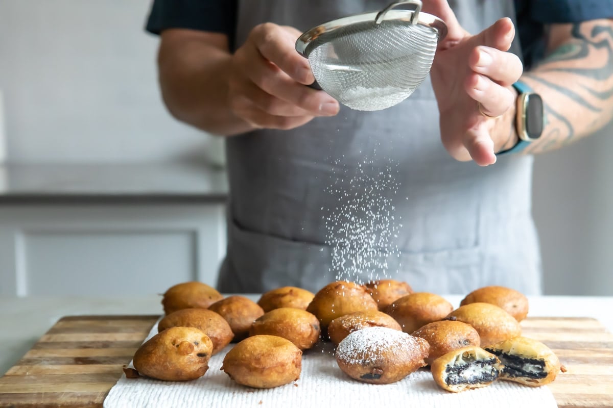 Dusting deep-fried oreos with powdered sugar.