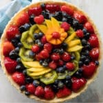 A fresh fruit tart on a counter top.