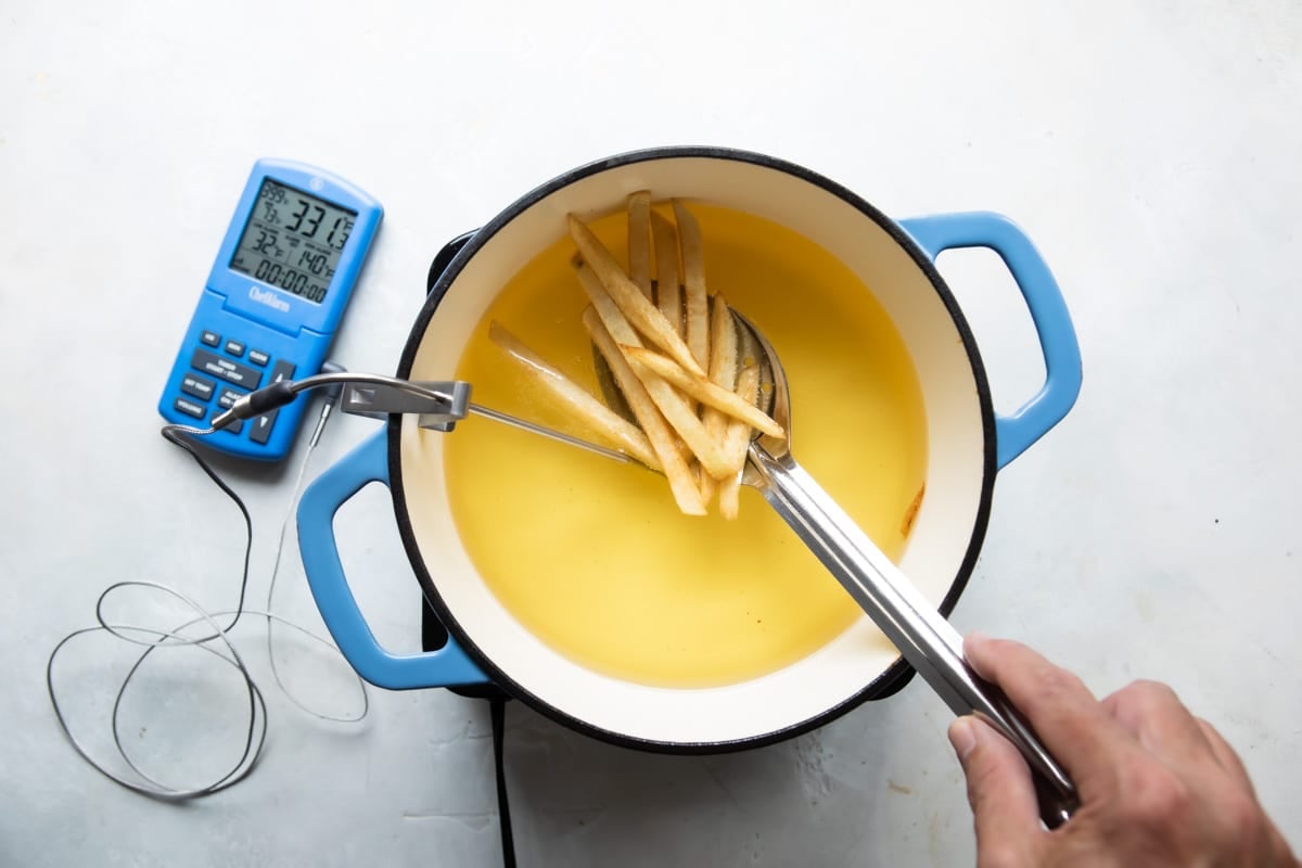 Frying French fries in a Dutch oven full of oil.