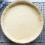 A tart crust on a cooling rack.