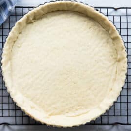 A tart crust on a cooling rack.