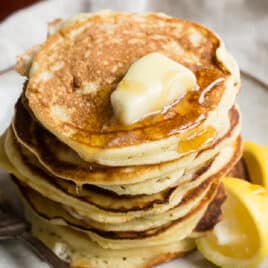 A stack of lemon ricotta pancakes on a plate.