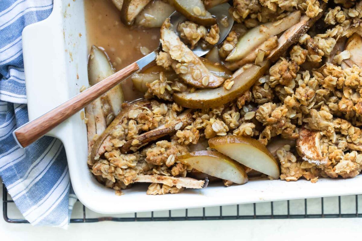 A white baking dish full of baked Pear Crisp.