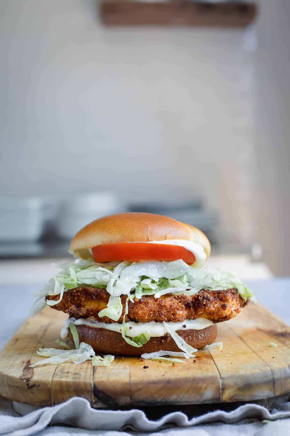A pork tenderloin sandwich on a board.
