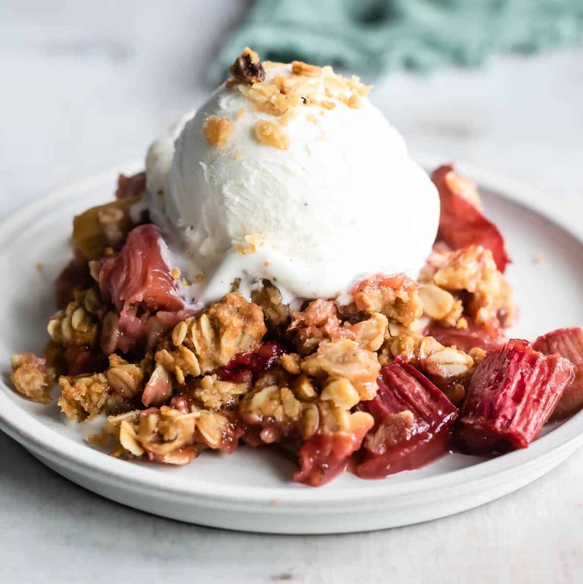 A dish of rhubarb crisp with ice cream.