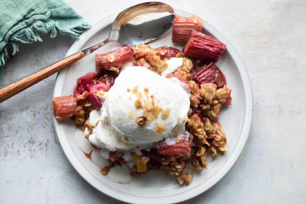 A dish of rhubarb crisp with ice cream.