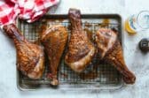 Smoked turkey legs on a baking rack.