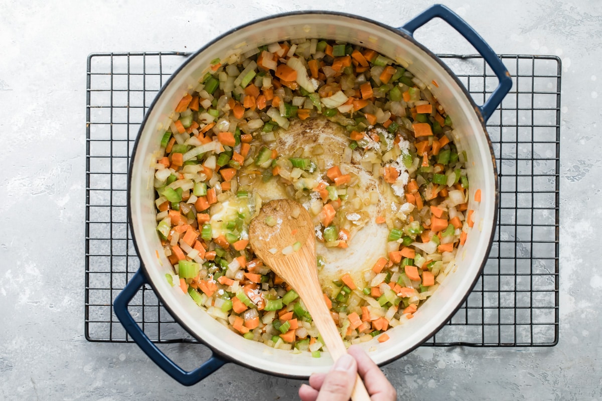 Carrots, onions, and celery cooking in a dutch oven.