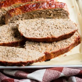 A turkey meatloaf with slices cut off on a baking sheet.
