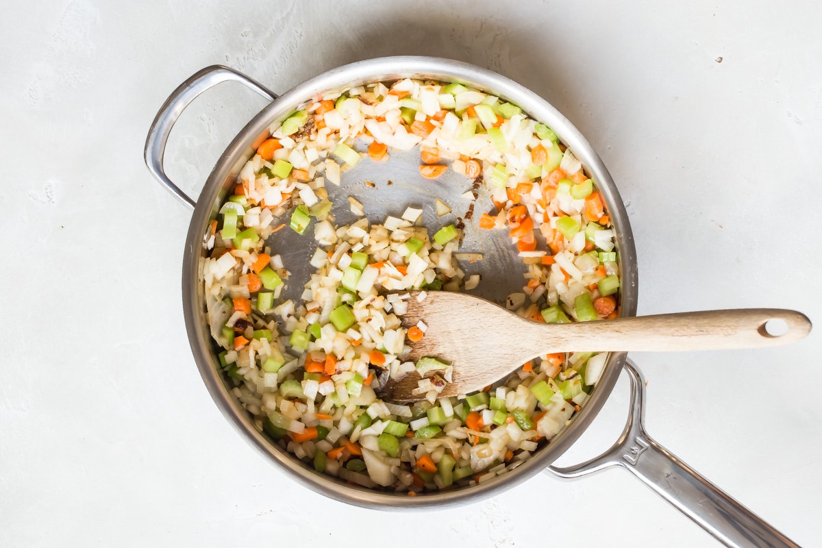 Vegetables cooking in a skillet for beef ragu.