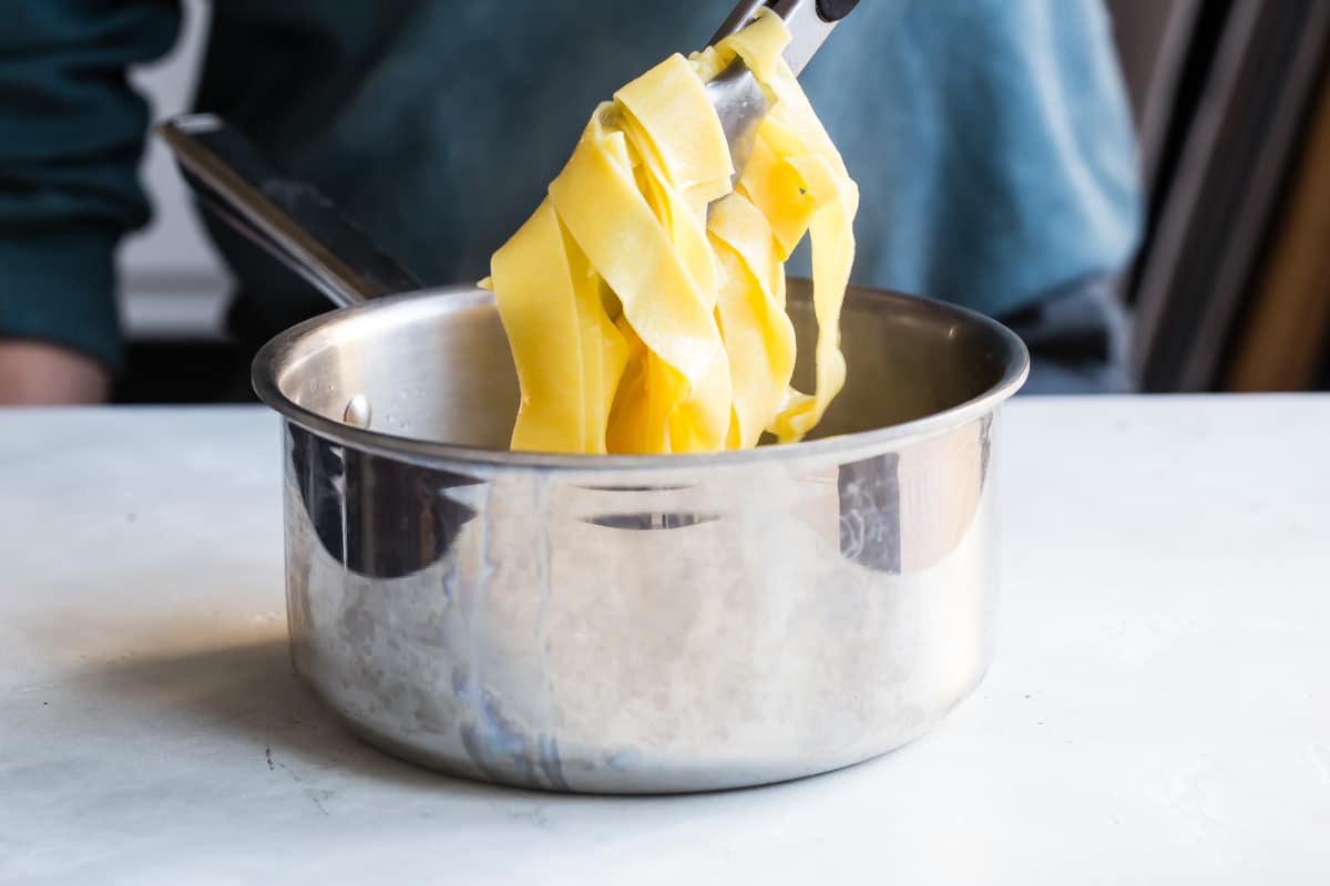 Cooking pappardelle in a pot for beef ragu.