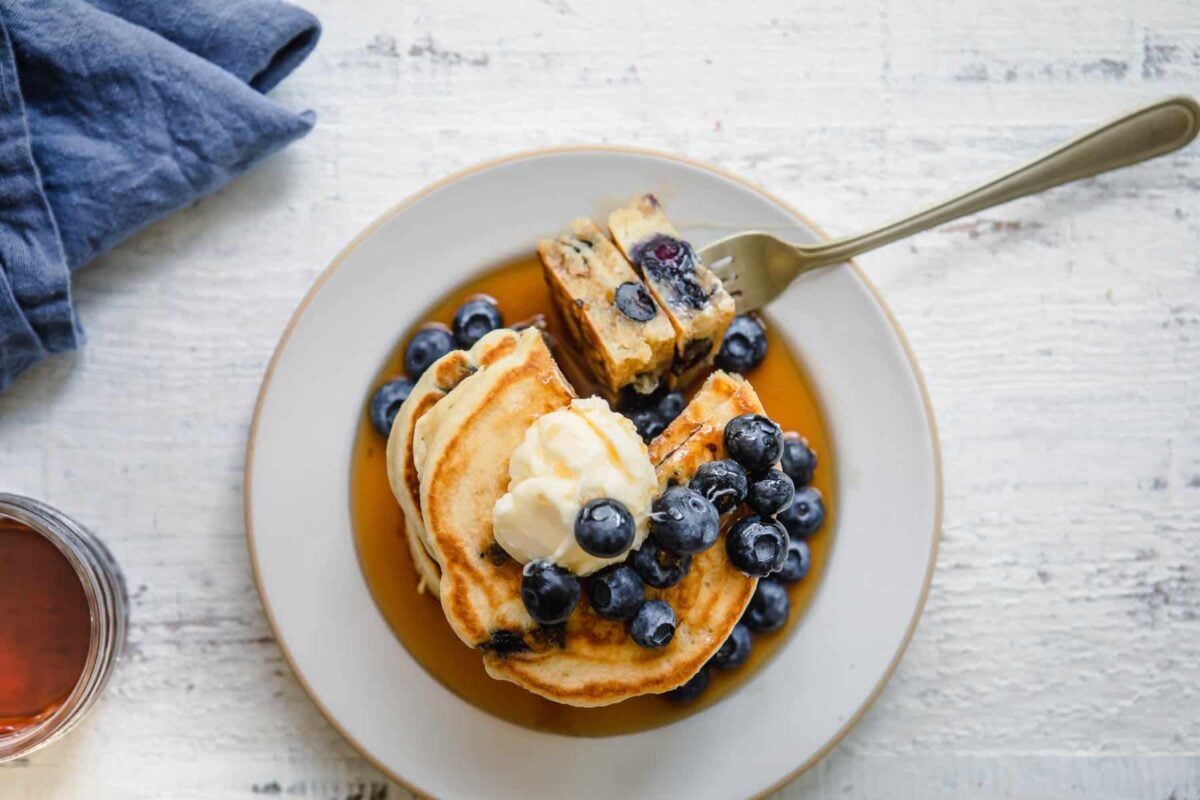 A stack of blueberry pancakes on a plate.
