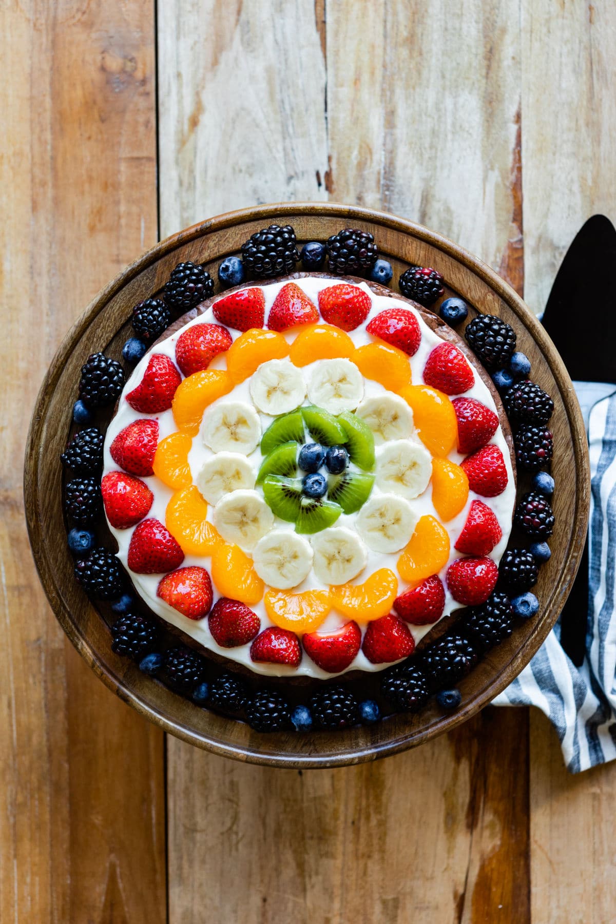 A brownie pizza on a wooden platter.